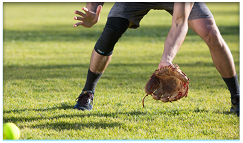 Man catching baseball wearing Copper Fit® Ice Knee Sleeves
