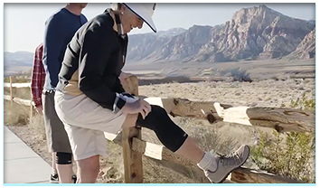 Man putting on Copper Fit® Ice Knee Sleeves before a hike